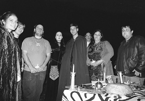 Participants in the Pagan Student Union celebration of Samhain gather in the Oval on Monday night behind a table holding items used in their ceremony.